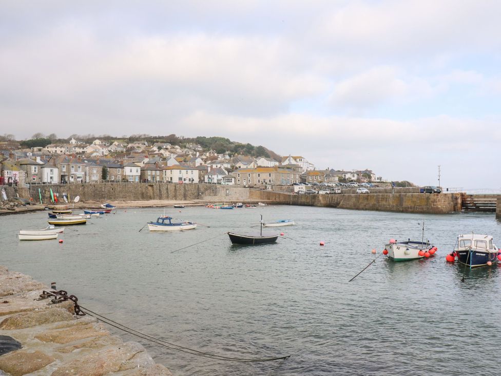 A harbor with boats and houses overlooking the water at Seafront Soliel in Penzance