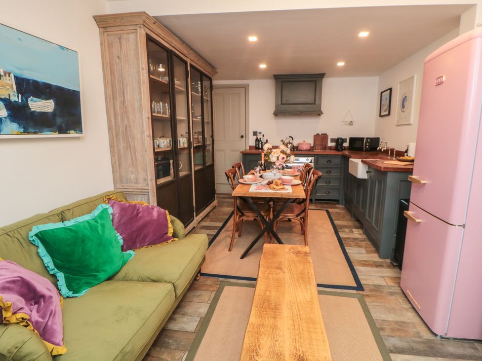 A kitchen with a dining table and pink fridge at Hillsover in Saltburn-by-the-Sea