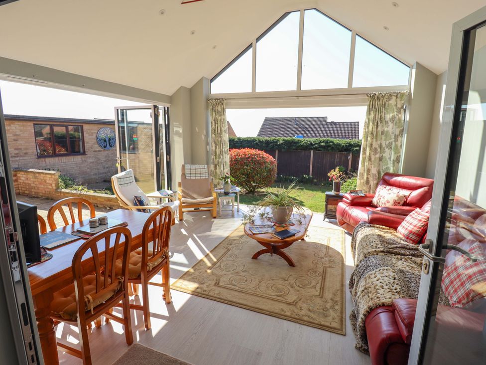 A conservatory with dining table and chairs at Seascape in Hunstanton
