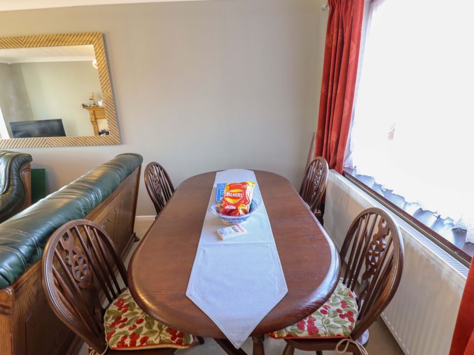A dining room with a table and chairs at Seascape in Hunstanton