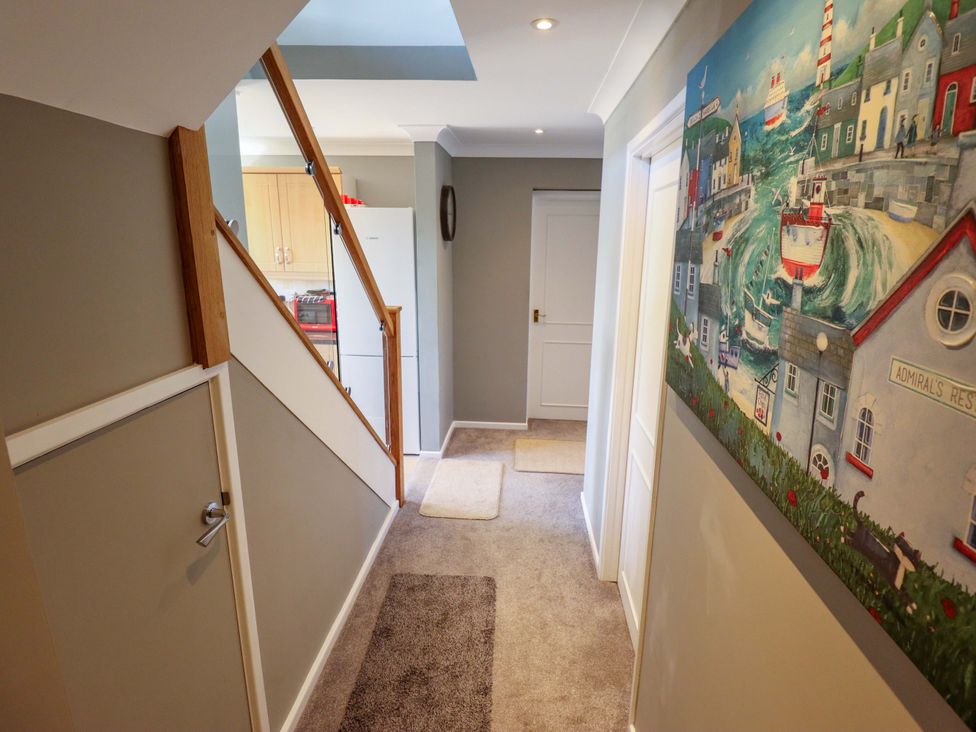 A hallway with stairs and a painting at Seascape in Hunstanton