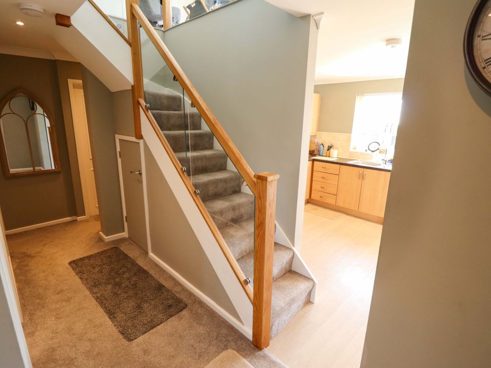 A hallway with stairs leading to kitchen at Seascape in Hunstanton