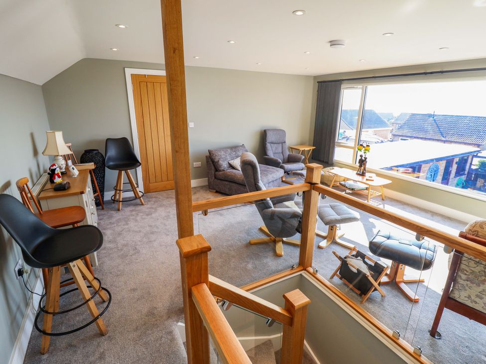 A living room with seating and a large window at Seascape in Hunstanton