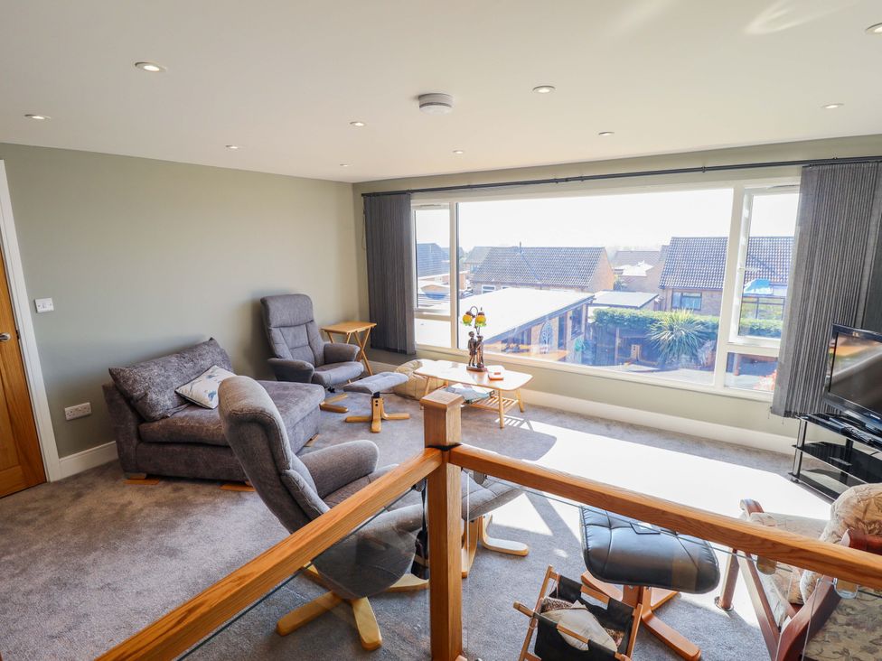 A living room with a view and furniture at Seascape in Hunstanton