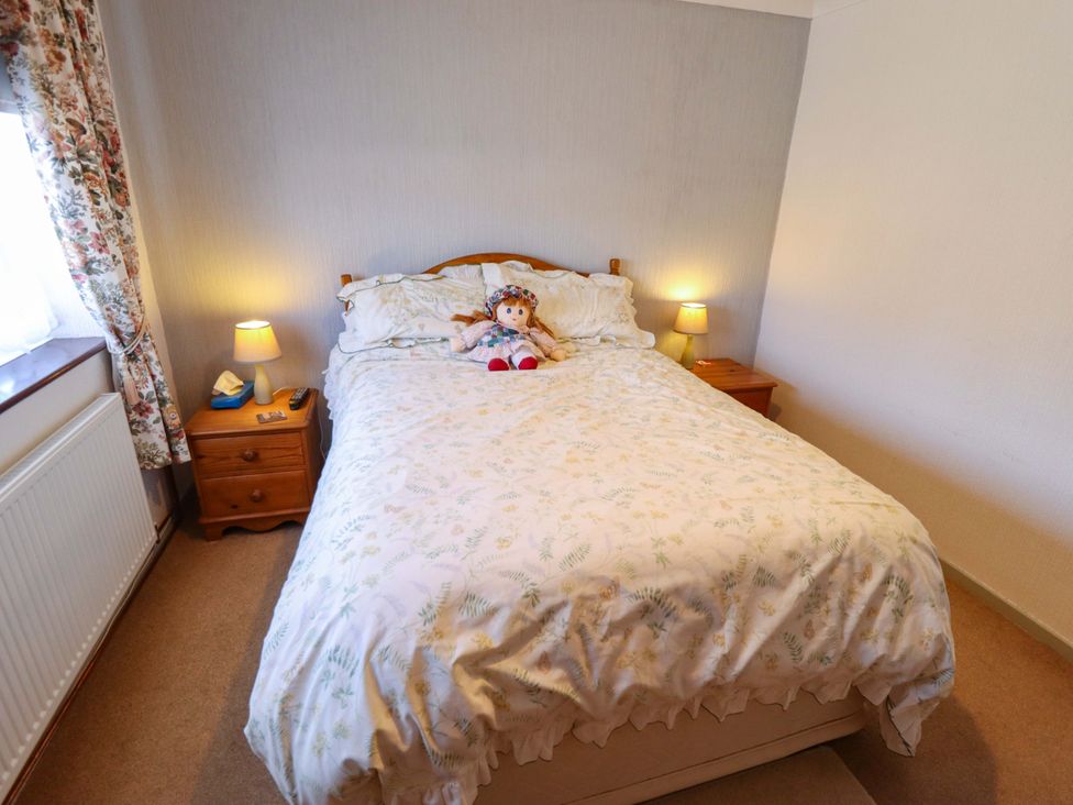 A bedroom with a bed and bedside lamps at Seascape in Hunstanton