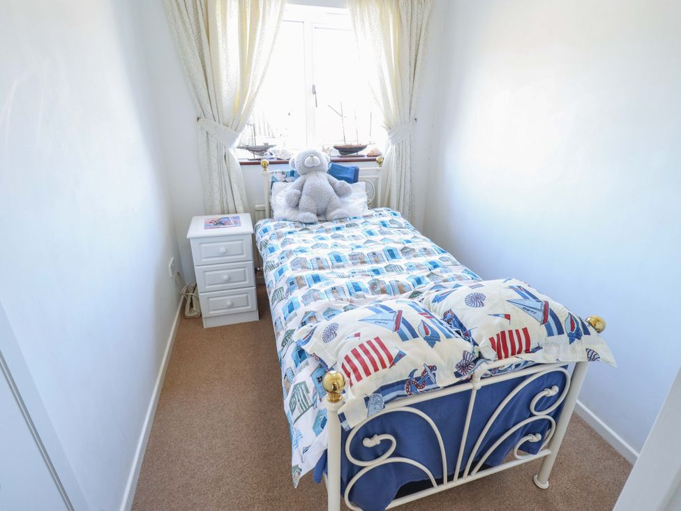 A bedroom with a bed and a teddy bear at Seascape in Hunstanton