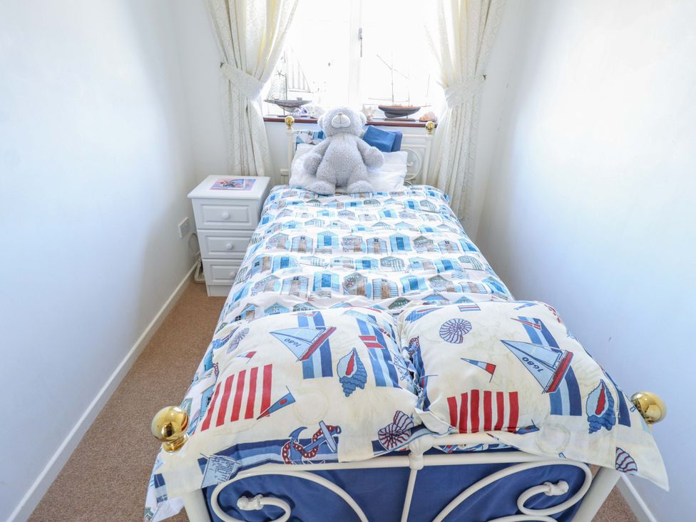 A bedroom with a bed and teddy bear at Seascape in Hunstanton