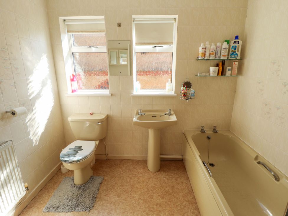 A bathroom with a sink, toilet, and bathtub at Seascape in Hunstanton