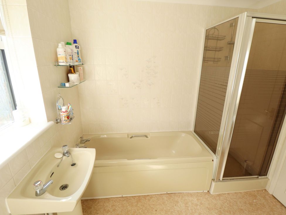 A bathroom with a bathtub and sink at Seascape in Hunstanton