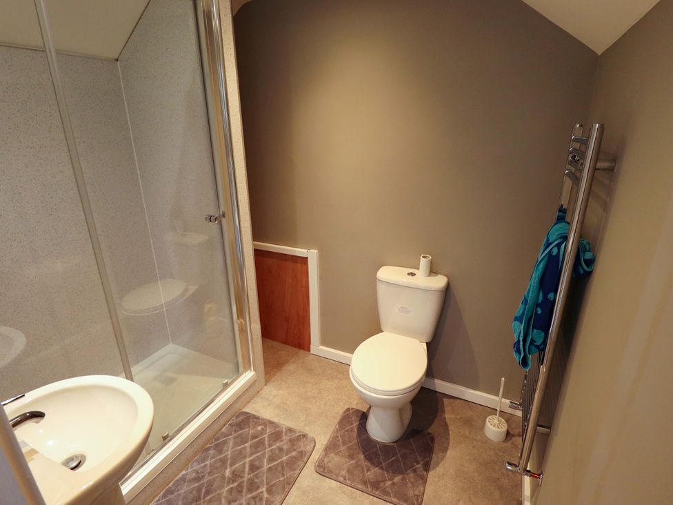 A bathroom with a shower, toilet, and sink at Seascape in Hunstanton