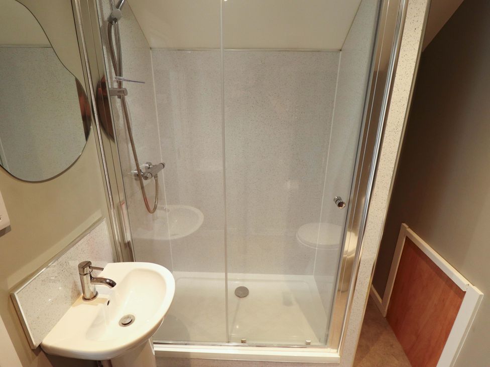 A bathroom with a shower and sink at Seascape in Hunstanton