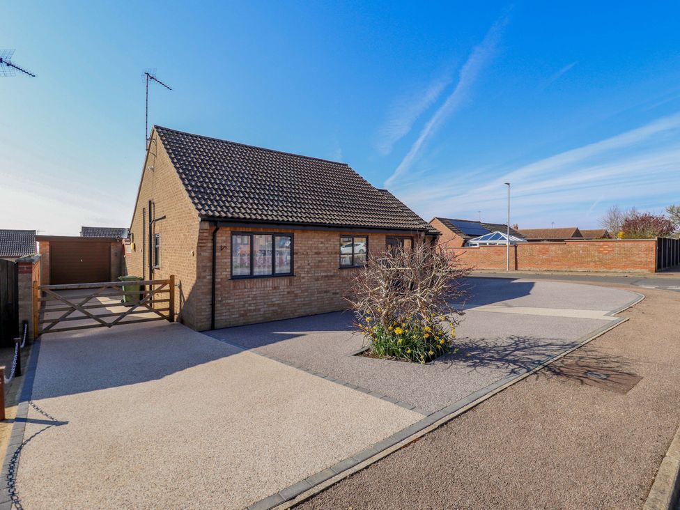A house with a driveway and flowerbed at Seascape in Hunstanton