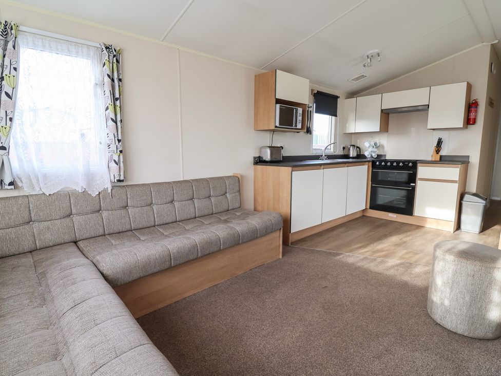 A living room with a sofa and kitchen area at Away Resorts - Golden Sands Holiday Park, C Rhyl