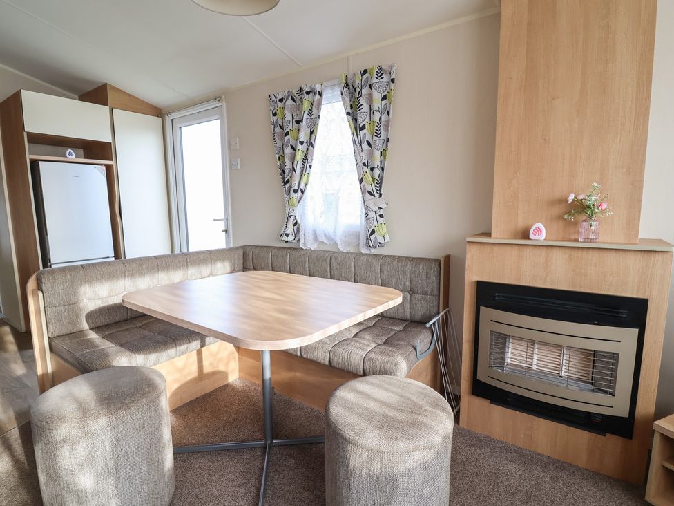A dining room with a table and sofa at Away Resorts - Golden Sands Holiday Park,  Rhyl