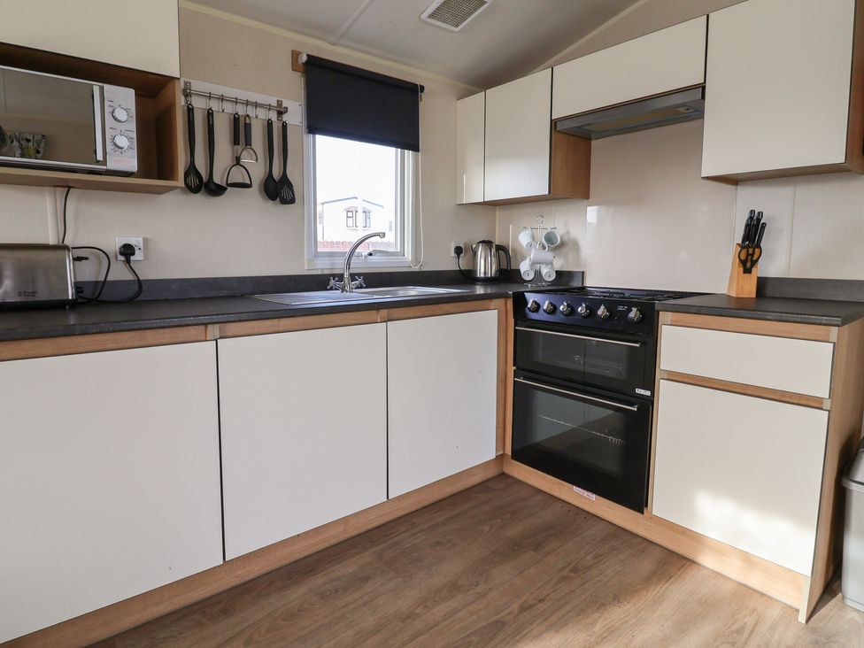 A kitchen with sink, cooking range, kettle, and cabinets at Away Resorts - Golden Sands Holiday Park, Rhyl