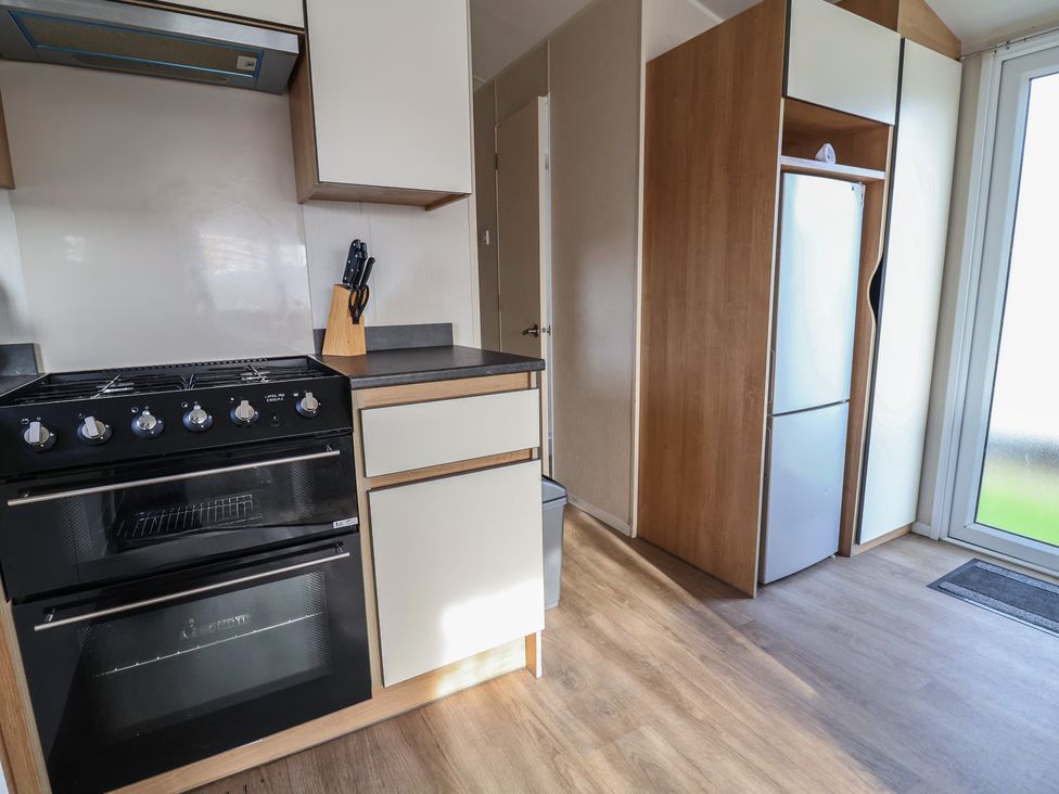 A kitchen with stove and refrigerator at Away Resorts - Golden Sands Holiday Park,  C in Rhyl