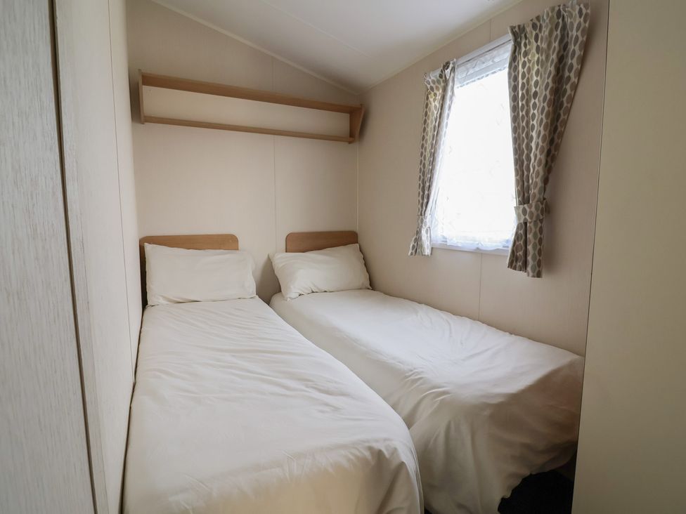A bedroom with two single beds and a window at Away Resorts - Golden Sands Holiday Park, Rhyl