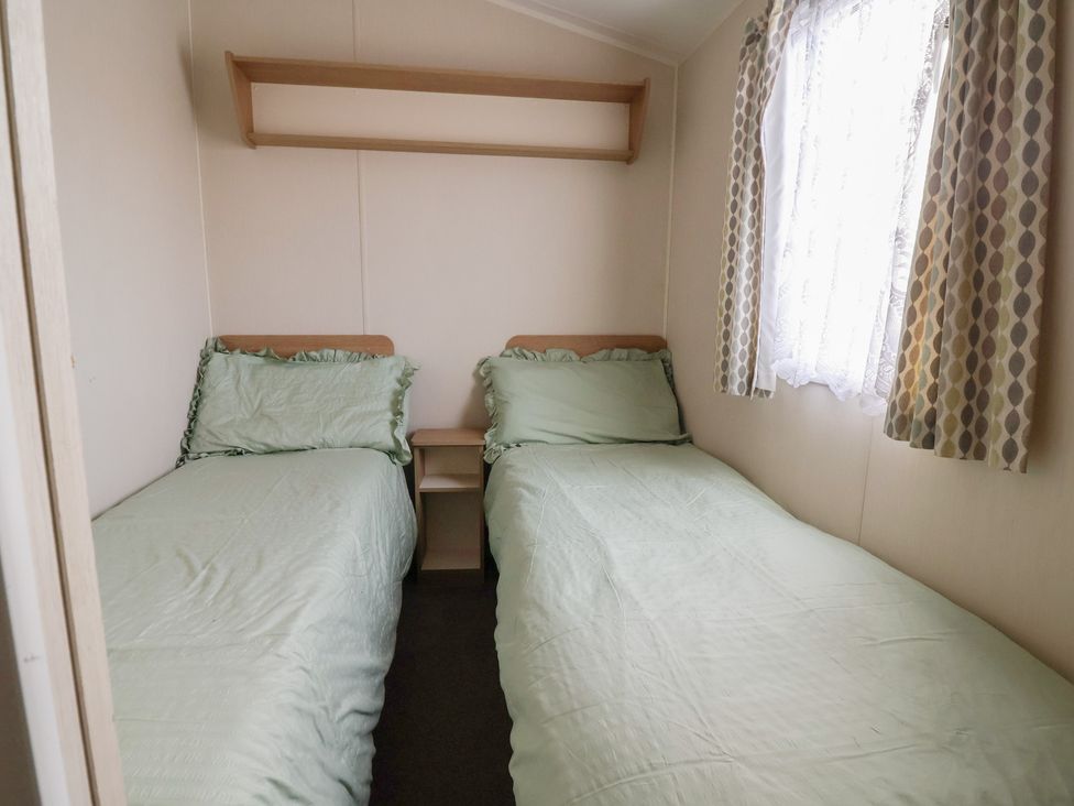 A bedroom with two beds and a shelf at Away Resorts - Golden Sands Holiday Park, Rhyl