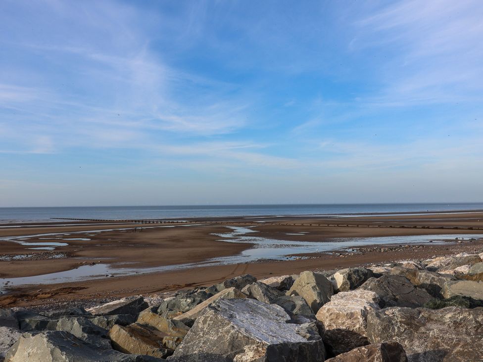 A beach scene with rocks and water at Away Resorts - Golden Sands Holiday Park, Rhyl