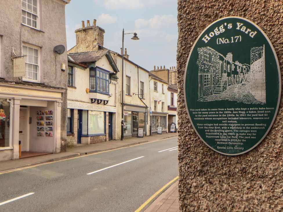 A street scene with buildings and a historical sign at The Old Bakehouse Kendal