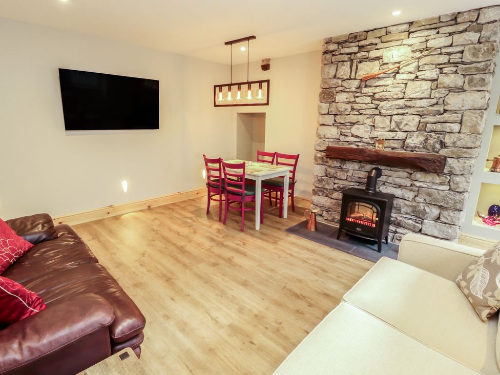 A living room with a television and dining area at The Old Bakehouse in Kendal
