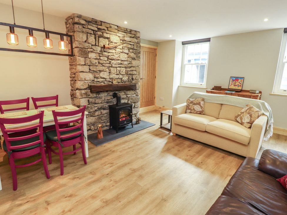 A living room with a couch and dining area at The Old Bakehouse in Kendal
