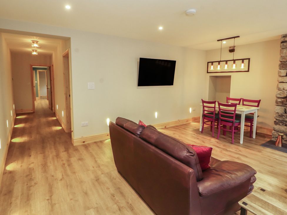 A living room with a sofa and dining area at The Old Bakehouse in Kendal
