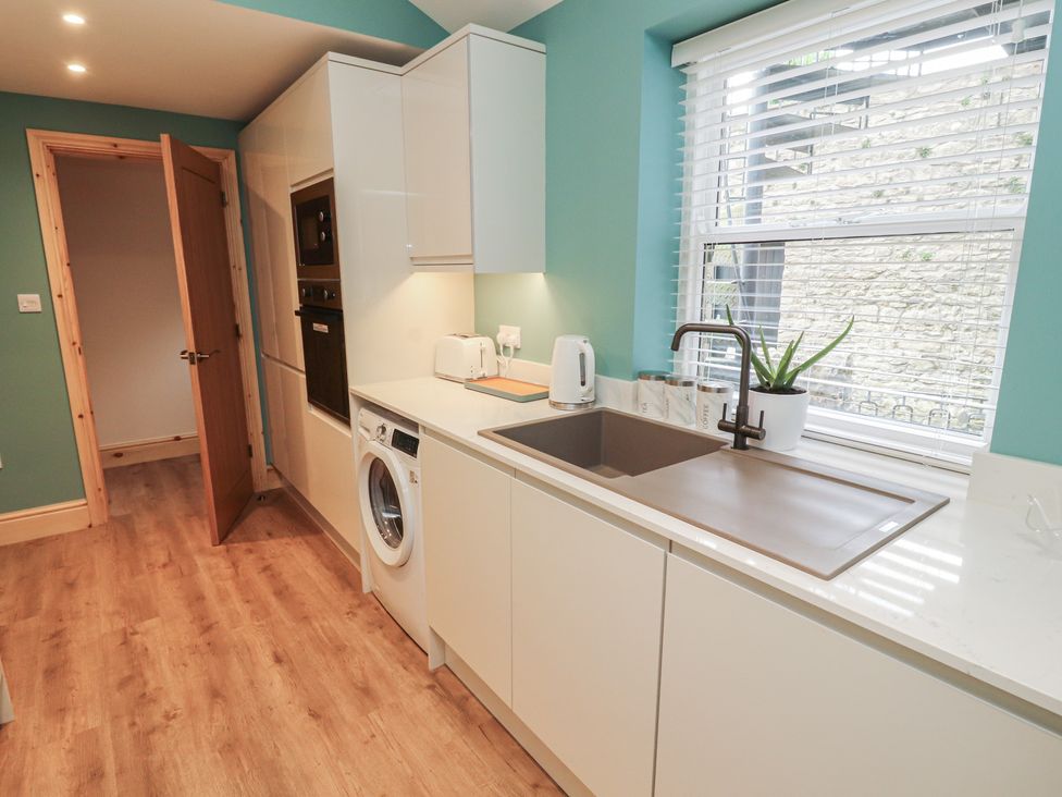 A kitchen featuring a sink, washing machine, and oven at The Old Bakehouse Kendal