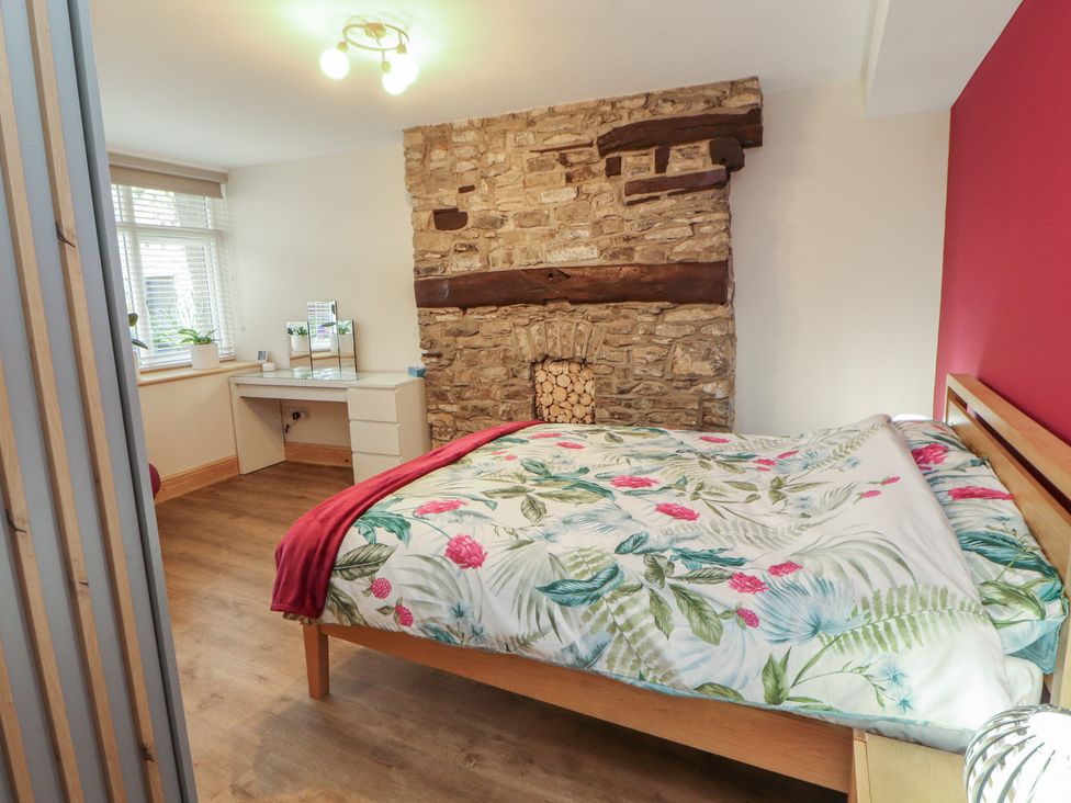 A bedroom with bed, desk, and fireplace at The Old Bakehouse in Kendal