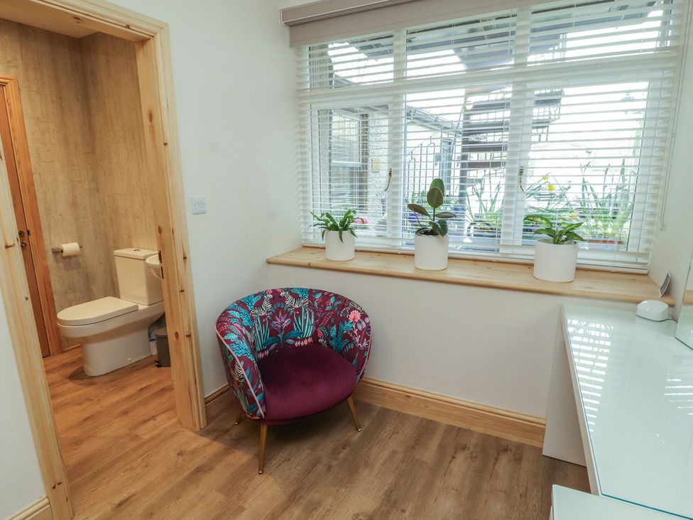 A bathroom with a toilet and a chair at The Old Bakehouse in Kendal