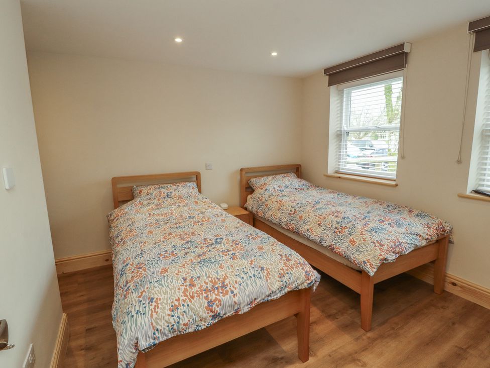 A bedroom with two beds and a window at The Old Bakehouse in Kendal