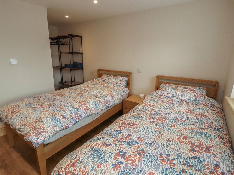 A bedroom with two beds and a shelf at The Old Bakehouse in Kendal