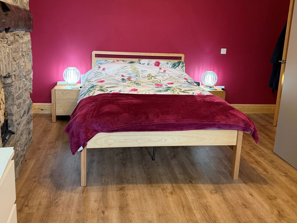 A bedroom with a bed and nightstands at The Old Bakehouse in Kendal
