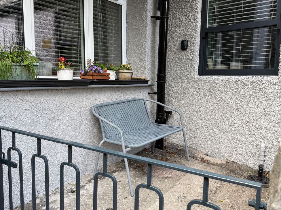An outdoor area with a chair and flower pots at The Old Bakehouse in Kendal