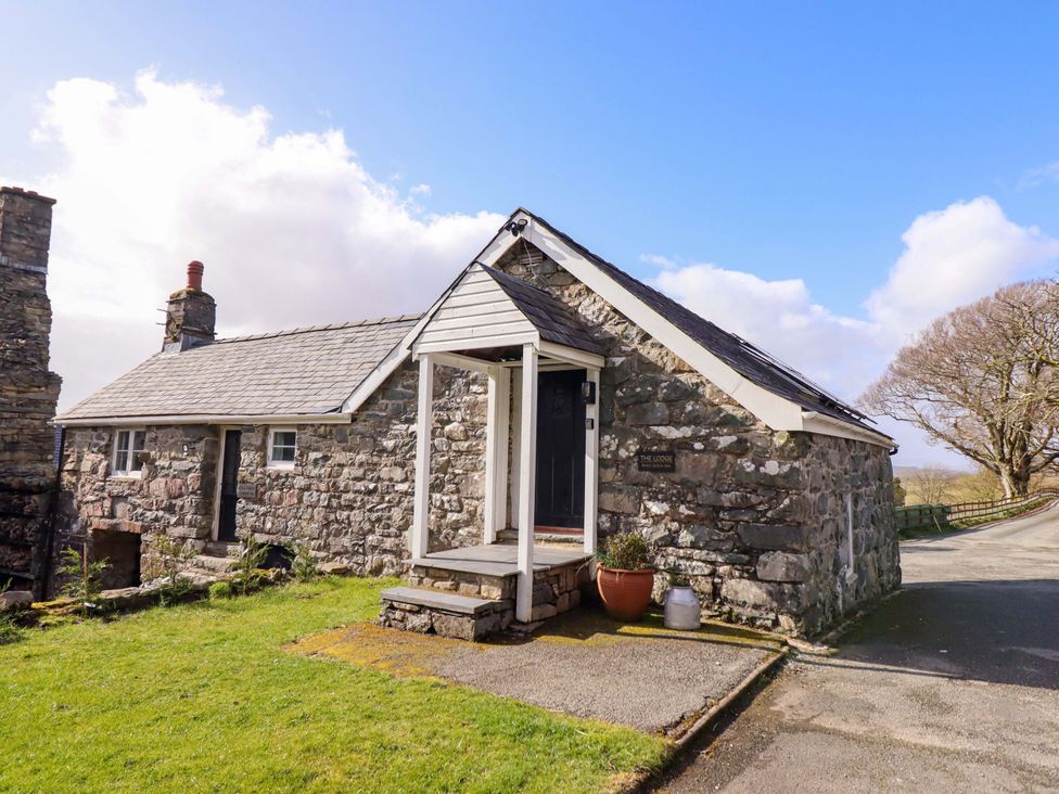 An exterior view of a stone house with a garden at The Lodge House at Rhiw Goch Inn in Snowdonia National Park
