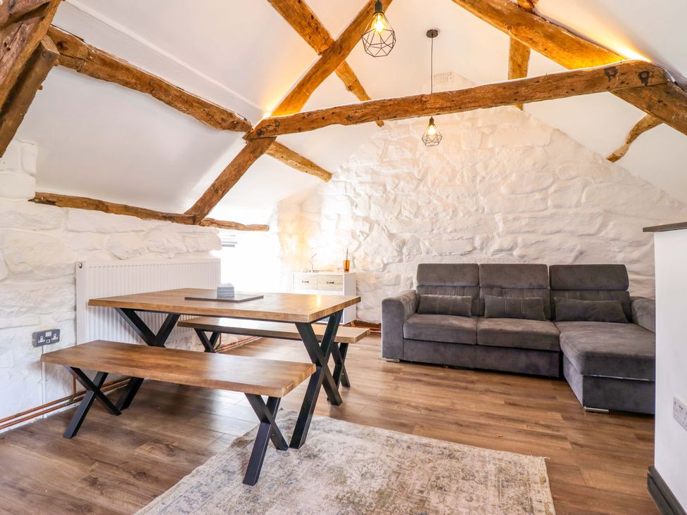 A living room with a table and sofa at The Lodge House at Rhiw Goch Inn Snowdonia National Park