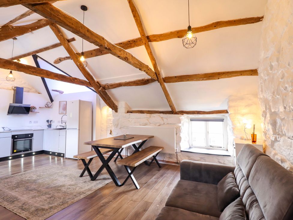 A living room with a kitchen area and dining table at The Lodge House at Rhiw Goch Inn, Snowdonia National Park