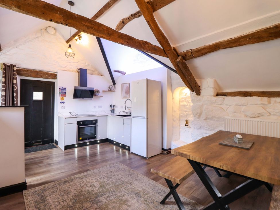 A kitchen with a dining table and appliances at The Lodge House at Rhiw Goch Inn in Snowdonia National Park