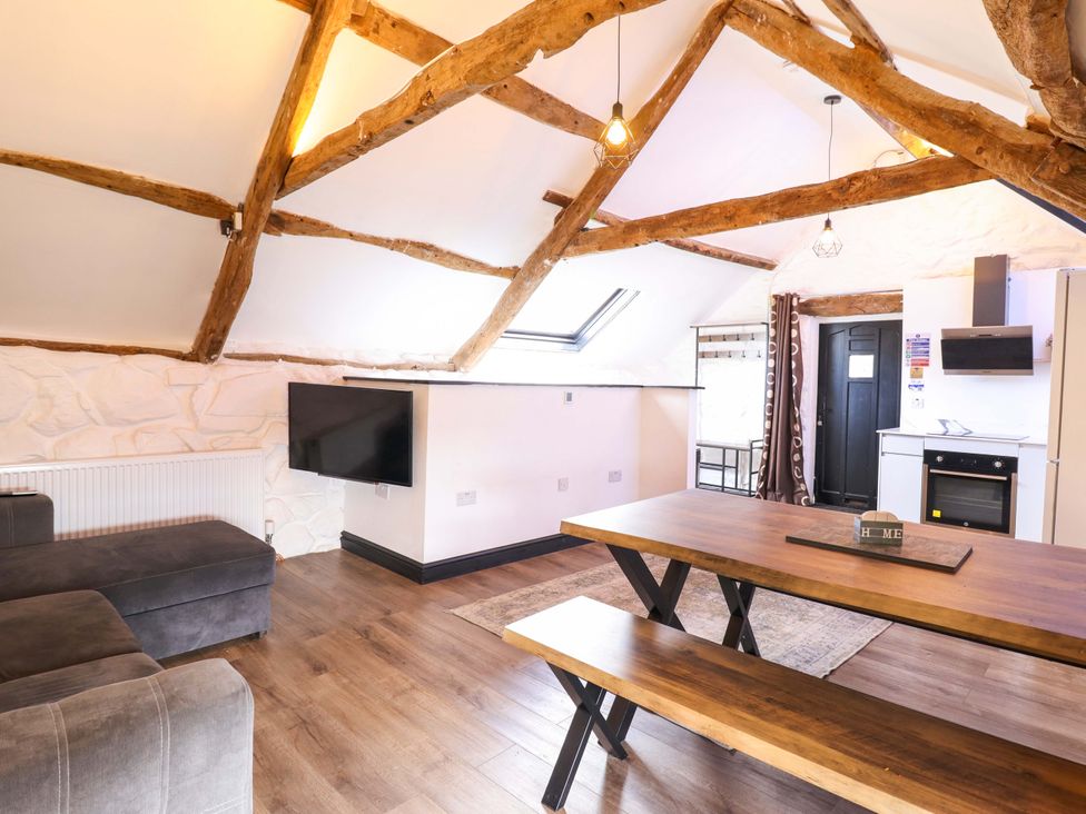 A living room with a sofa and dining table at The Lodge House at Rhiw Goch Inn Snowdonia National Park