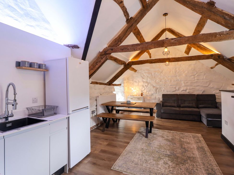 A living room with a kitchen area and dining table at The Lodge House at Rhiw Goch Inn, Snowdonia National Park