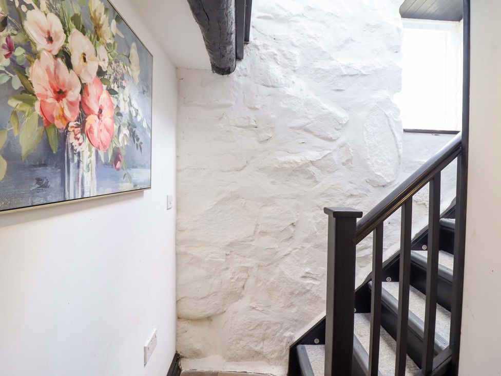 A staircase with a painting on the wall at The Lodge House at Rhiw Goch Inn, Snowdonia National Park