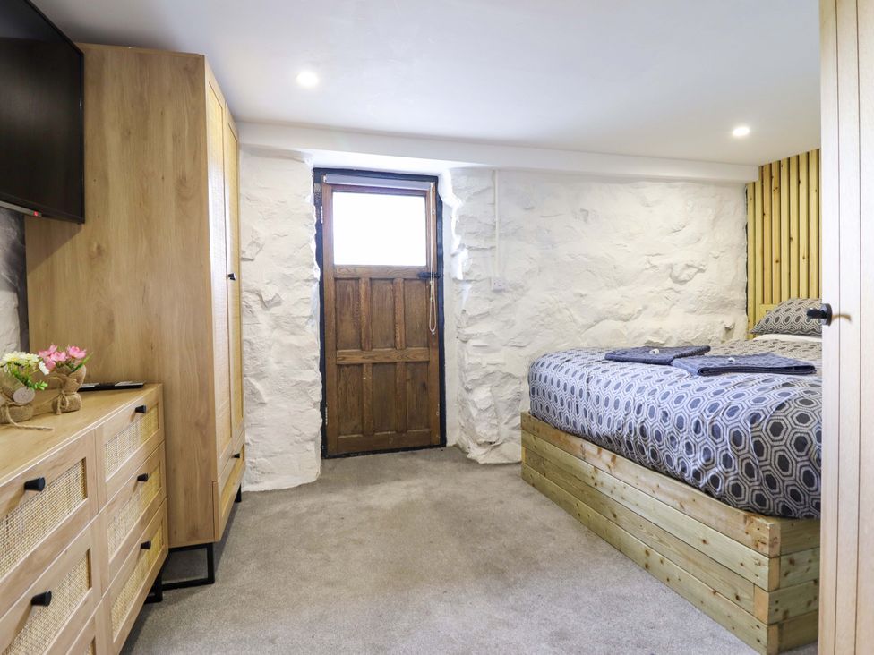 A bedroom with a bed and dresser at The Lodge House at Rhiw Goch Inn Snowdonia National Park