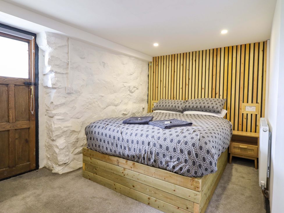A bedroom with a bed and wooden door at The Lodge House at Rhiw Goch Inn Snowdonia National Park