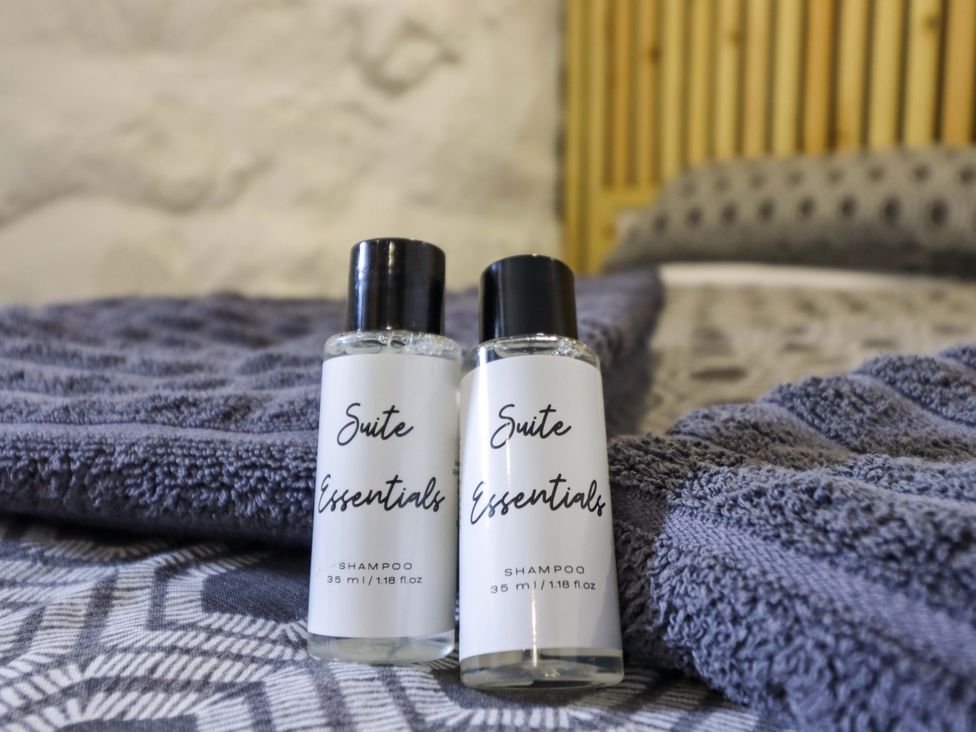 Two shampoo bottles on a towel at The Lodge House at Rhiw Goch Inn, Snowdonia National Park