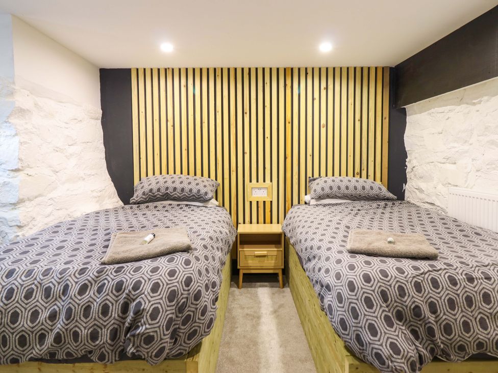 A bedroom with two beds and a nightstand at The Lodge House at Rhiw Goch Inn in Snowdonia National Park