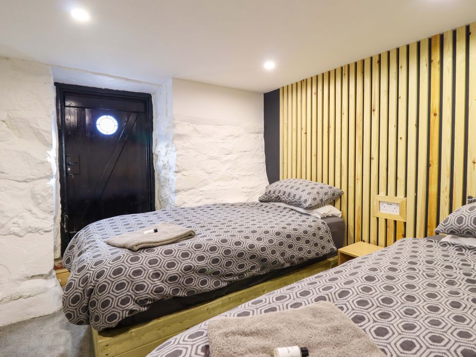 A bedroom with two beds and a door at The Lodge House at Rhiw Goch Inn, Snowdonia National Park