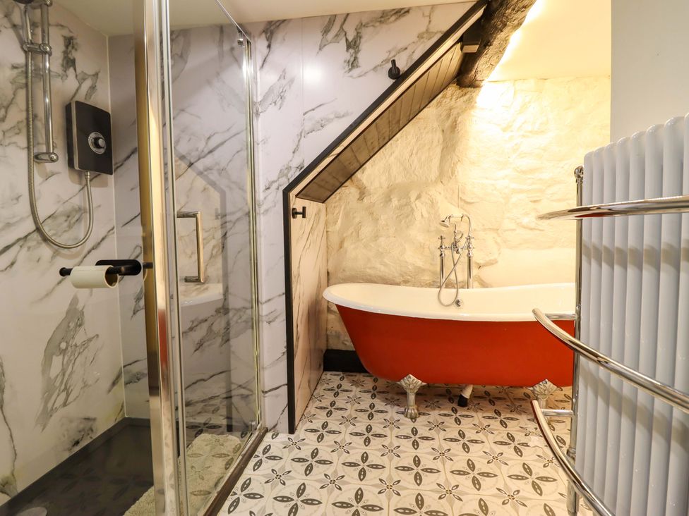A bathroom with a shower and bathtub at The Lodge House at Rhiw Goch Inn in Snowdonia National Park