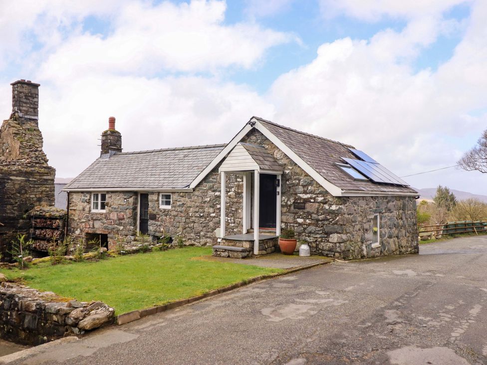 A stone house with solar panels and a garden at The Lodge House at Rhiw Goch Inn Snowdonia National Park