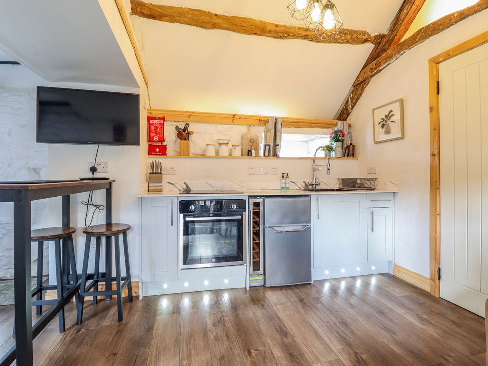 A kitchen with appliances and bar stools at The Romantic Hideaway at Rhiw Goch Inn, Snowdonia National Park