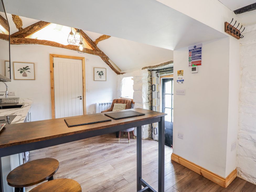 A kitchen with a bar counter and stools at The Romantic Hideaway at Rhiw Goch Inn Snowdonia National Park